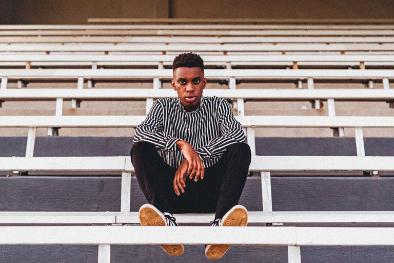 Photo of young man sitting in bleachers